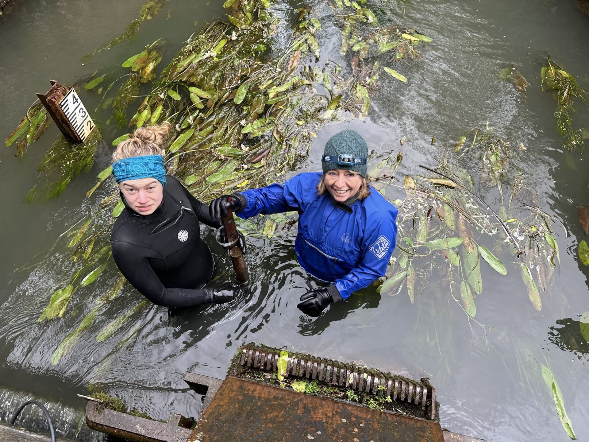 two people in a river with testing equipment