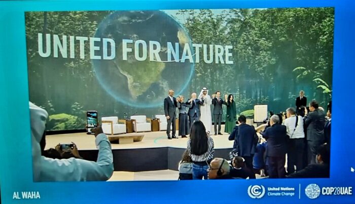 Screen image of 6 people holding hand in front of banner which says 'united for nature'