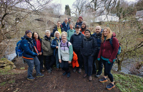 Group of 12 researchers standing ona riverside.